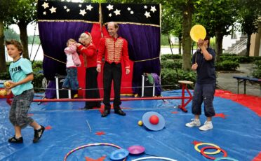Clown Snoepy entertains kinderen bij een circusshow met kleurrijk decor.