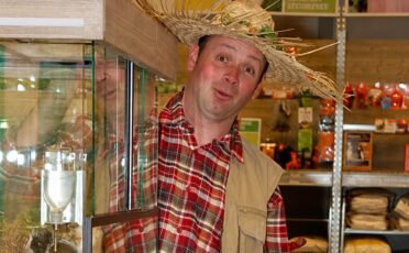 Clown Snoepy met strooien hoed in winkel, vrolijk en speels.