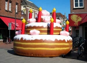 Grote opblaasbare taart met kaarsen voor feestelijke evenementen.