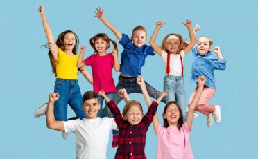 Vrolijke kinderen met handen in de lucht, plezier en lachen.
