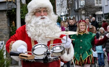 Clown Snoepy speelt op drums tijdens de parade in een drukke straat.