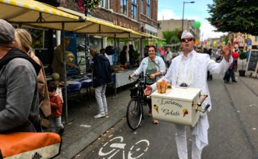 Clown Snoepy verkoopt ijs op straat tijdens een evenement.