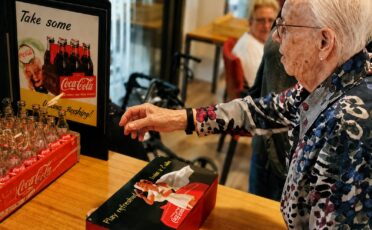 Oudere mensen genieten van kermisactiviteiten met Clown Snoepy in zorgcentrum.
