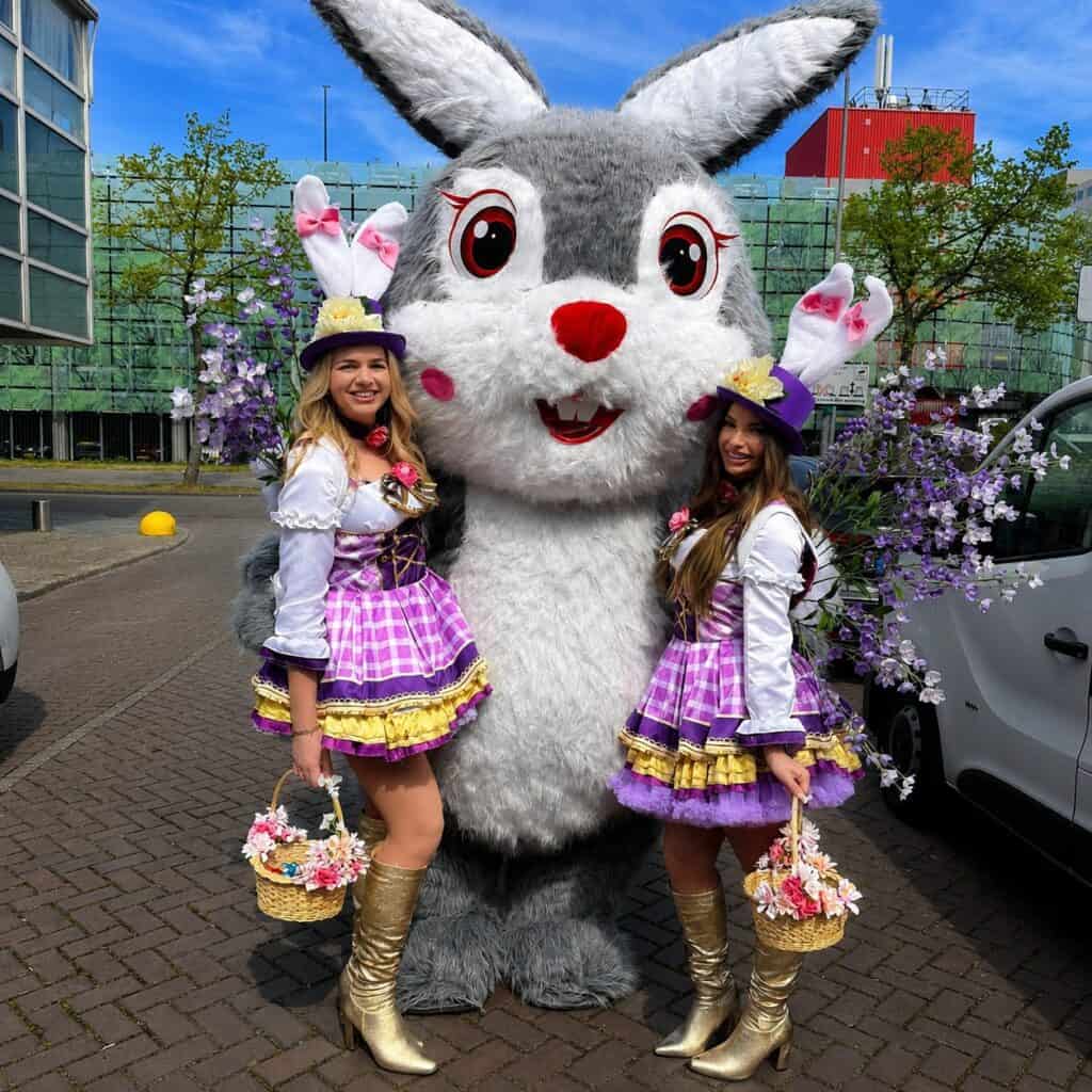 Feestelijke dames met clown Snoepy in kleurrijke outfits.