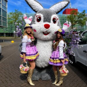 Feestelijke dames met clown Snoepy in kleurrijke outfits.