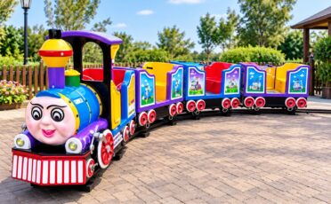 Kleurrijke kindertrein op rails voor kinderen op speelplaats.