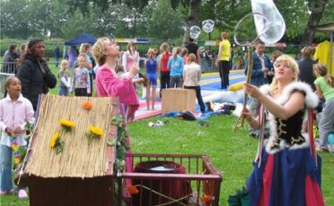 Clown Snoepy entertaint kinderen met bellenblaas op kinderfestival.