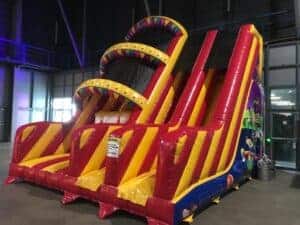 Groot kleurrijk springkussen met glijbaan voor kinderen.